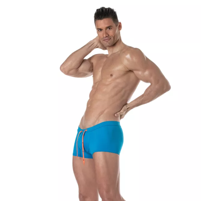 Mini Boxer De Bain Uni Turquoise avec un homme debout